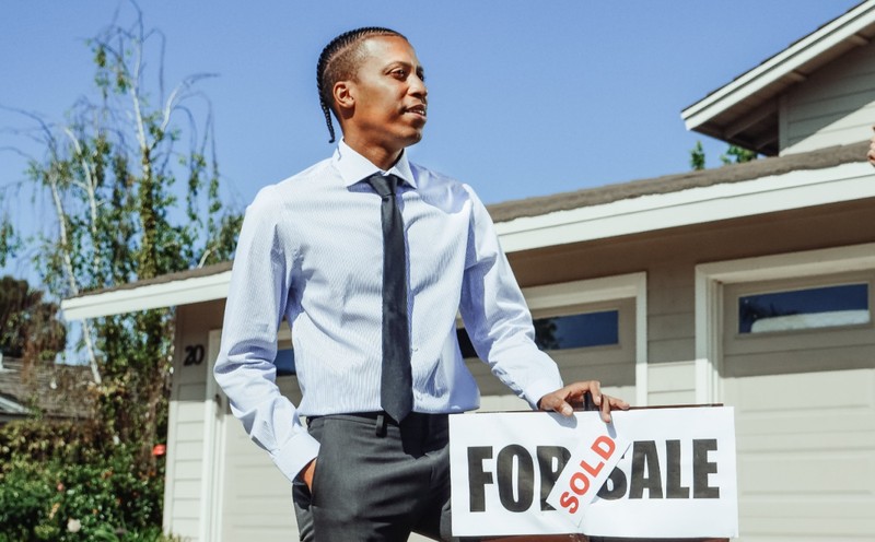 Realtor Holding a ‘For Sale’ Sign