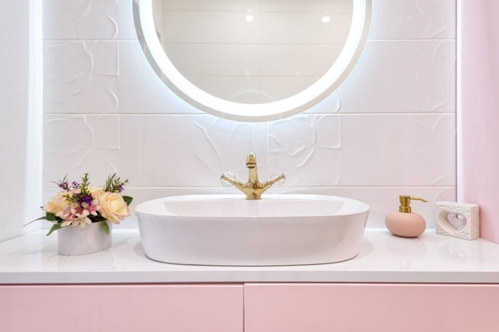 A close-up photo of a shiny bathroom mirror hanging above a sleek sink.